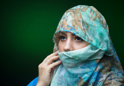 Portait of woman wearing a blue scarf with eyes closed