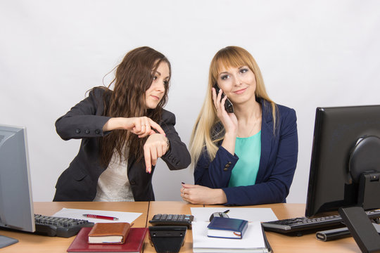 The situation in the office - the employee shows to watch that for a long time colleague talking on the phone