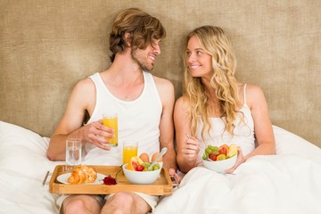Cute couple having breakfast in bed