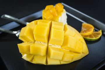 Fresh mango and mango crepe cake on black dish
