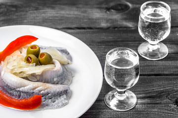 Fototapeta na wymiar Marinated herring and vodka shot. Traditional polish appetizer.
