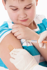 Doctor giving a child injection in arm on isolated image.