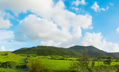 green hills under a blue sky with clouds