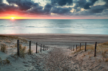 sand path to North sea beach at sunset