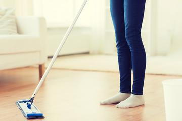 close up of woman with mop cleaning floor at home