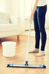 close up of woman with mop cleaning floor at home