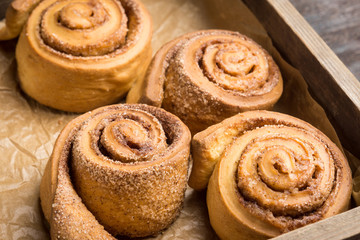 Cinnamon rolls on the wooden background