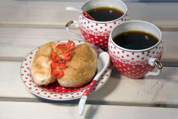 croissants and two cup of coffee on white wooden background