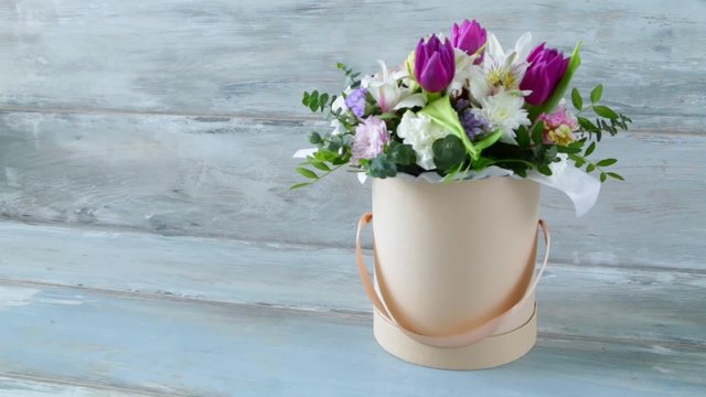 Beautiful summer bouquet of flowers in the hat box on the vintage blue wooden background 