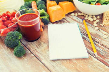 close up of ripe vegetables and notebook on table