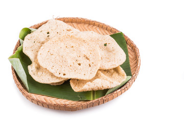Freshy fried delicious fish crackers snack served on traditional rattan tray with white background