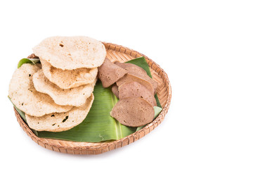 Freshly fried and dried raw fish crackers served on rattan tray with white background