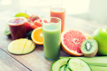 close up of fresh juice glass and fruits on table