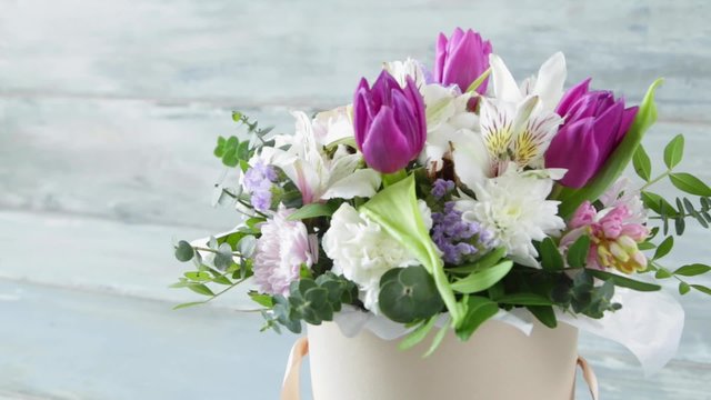 This video is about beautiful basket of flowers stylish bouquet spring tone wood background 