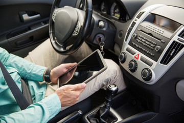 close up of young man with tablet pc driving car