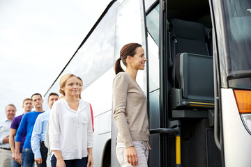 group of happy passengers boarding travel bus