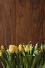 yellow tulips lying on wooden table