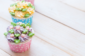 many sweet birthday cupcakes with flowers and butter cream