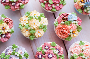 many sweet birthday cupcakes with flowers and butter cream