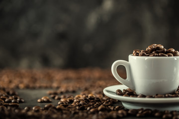 Coffee beans. Coffee cup full of coffee beans. Toned image.