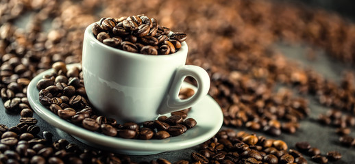 Coffee beans. Coffee cup full of coffee beans. Toned image.