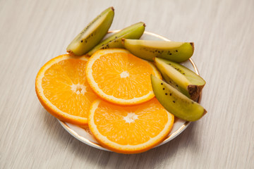 a plate of oranges and kiwi