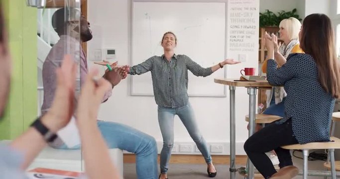 Crazy happy business woman dancing doing victory dance in team meeting celebrating success achievement