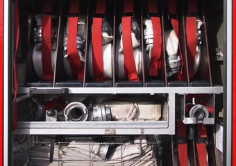 Inside of a fire truck - fire hoses prepared for usage.