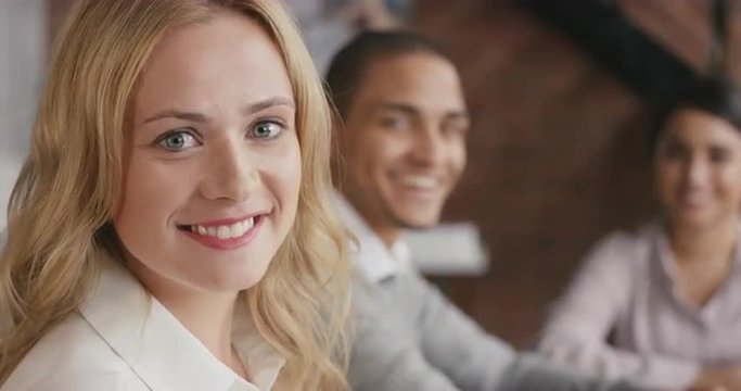 Portrait of a confident young business woman  at boardroom table In slow motion turning around and smiling