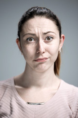 Woman is looking imploring over gray background