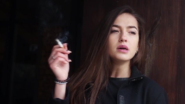 Beautiful Woman Smokes a Cigarette.