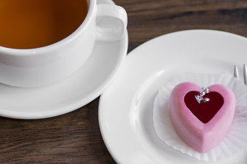 Cake in the form of heart and a cup of tea