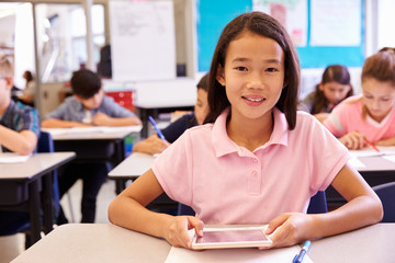 Schoolgirl using tablet computer in elementary school class