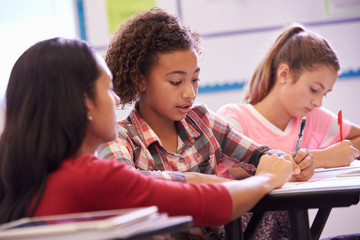Teacher helping elementary school pupils in class