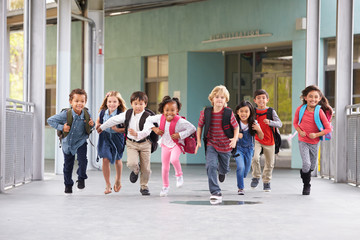 Group of elementary school kids running in a school corridor - Powered by Adobe