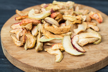 Dried apples, on cutting board, on wooden background