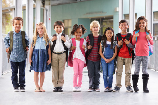 Group of elementary school kids standing in school corridor