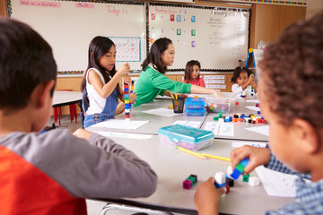 Fototapeta premium Elementary school teacher uses block play in class with kids