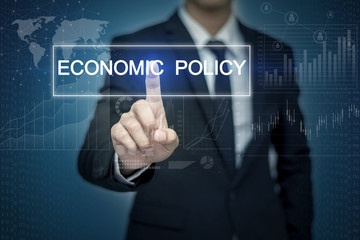 Businessman hand touching ECONOMIC POLICY  button on virtual scr