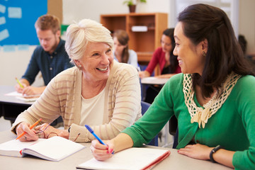 Teacher and student sit together at an adult education class