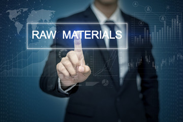 Businessman hand touching RAW MATERIALS  button on virtual scree