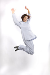 giovane donna in pigiama grigio , salta su sfondo bianco - obrazy, fototapety, plakaty