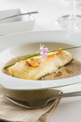 Hake fillet served in a garlic sauce