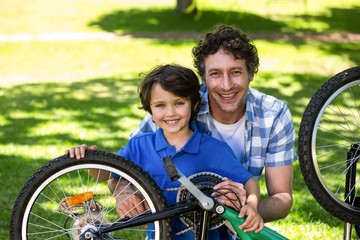 Obraz premium Father and son fixing the bike