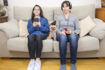 Mother and daughter listening to music on a walkman and a smartphone
