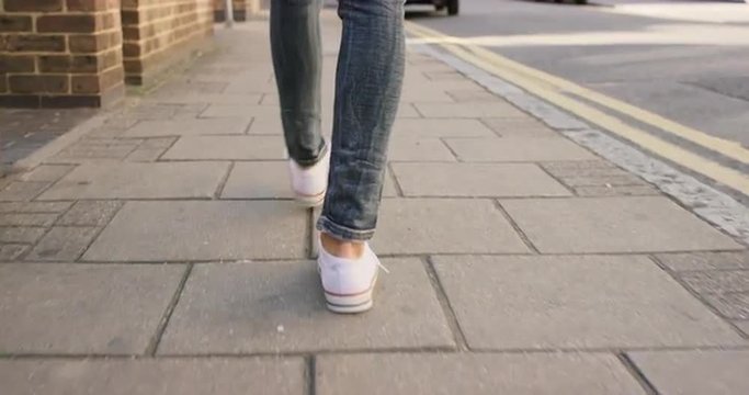 Detail of woman's feet walking through city
