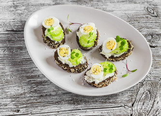 Open sandwiches with cream cheese, quail eggs and celery. Delicious healthy Easter snack or breakfast