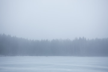 Thick fog at frozen lake landscape