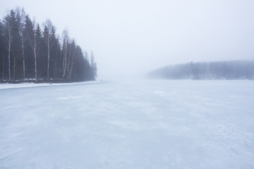 Thick fog at frozen lake landscape