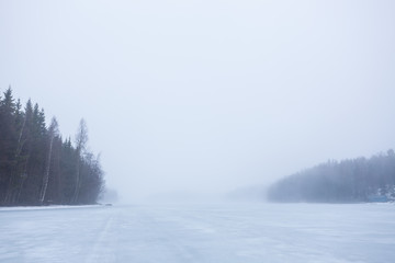Thick fog at frozen lake landscape